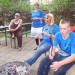 Jugendliche backen Stockbrot über dem Holzkohlengrill. Jugendliche backen Stockbrot über dem Holzkohlengrill.