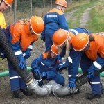 Kinder und Jugendliche der Jugendfeuerwehr kuppeln Geräte aneinander.