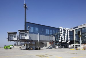 Im Juni installierte der Berliner Künstler Olaf Nicolai an der Fluggastbrücke des A380 ein riesiges Kunstwerk, das die Brücke wie Perlen schmückt. (Foto: Flughafen Berlin-Brandenburg, Alexander Obst / Marion Schmieding)