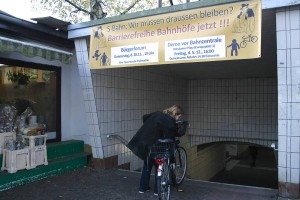 Nicht nur für Leute, die mit dem Fahrrad unterwegs sind, stellt der Zugang zum S-Bahnhof ein echtes Hindernis dar. Aktivisten des Bündnisses aus Politik und Bürgerschaft haben ein Transparent zum Aufruf zur Demonstration an den Zugang zum Bahnsteig gehängt. (Foto: Jörg Levermann)